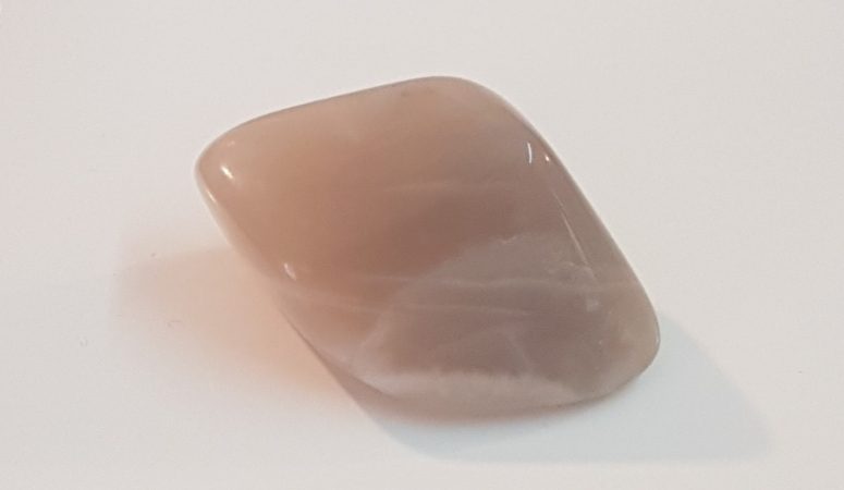 Picture of a moonstone, with grey-ish/beige colour, on a white background