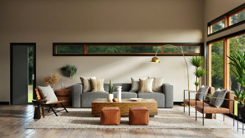 image of a living room, grey couch pushed against a beige wall, there is a long but thin window on the wall, above the couch, there's a wooden coffee table with 2 brown footstools